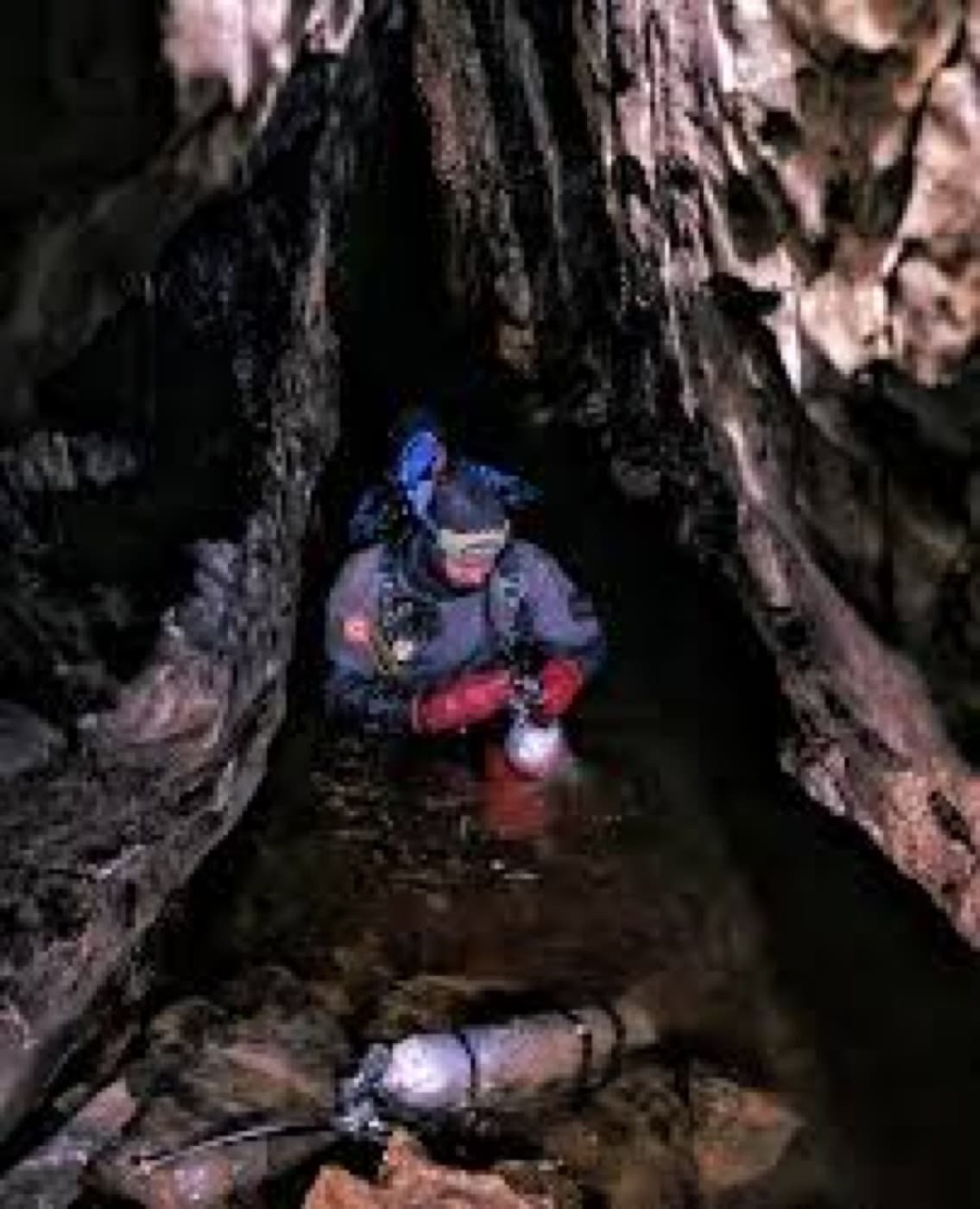 Technical diver moving through a flooded cave passage.